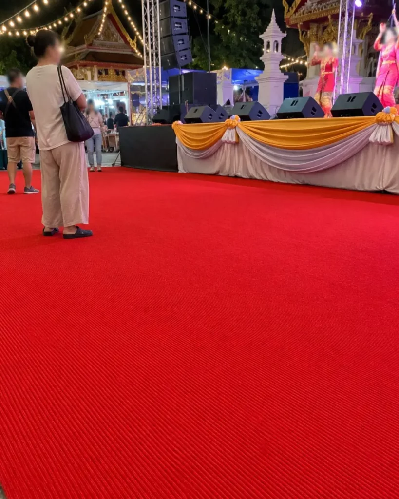 ทางเดินพรมแดงภายในงานวัด พร้อมผู้เข้าร่วมงาน